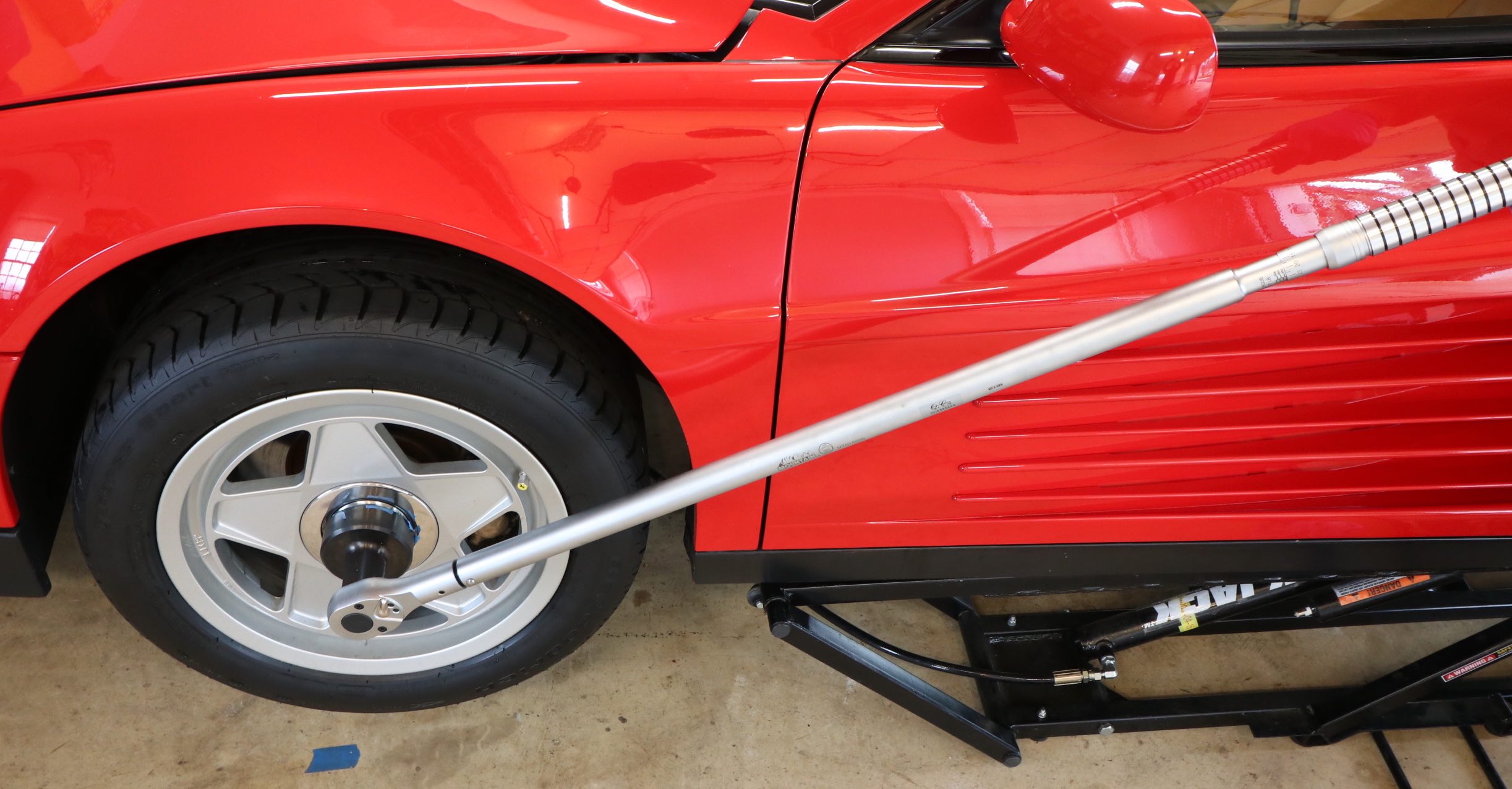 Tightening Ferrari Testarossa single wheel nut with a torque wrench